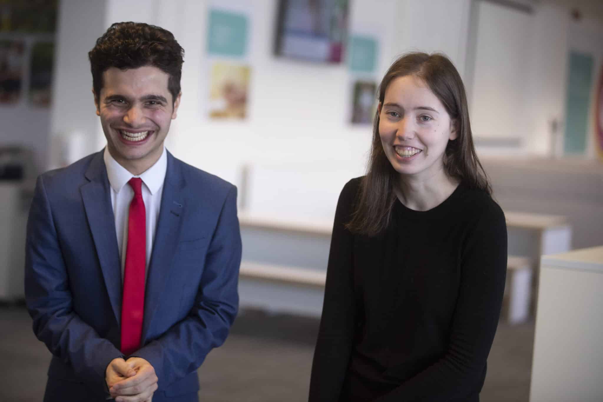 Two students looking at camera smiling