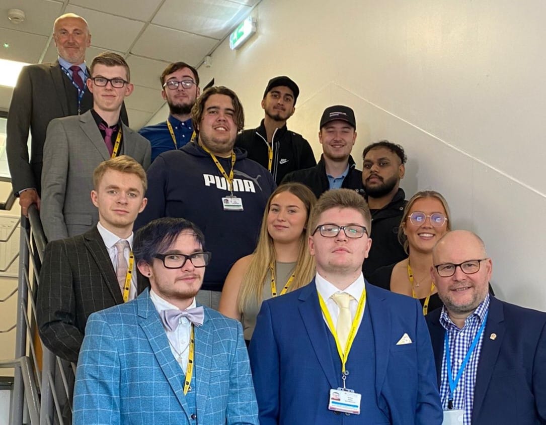 Group of students standing in stairs with tutors