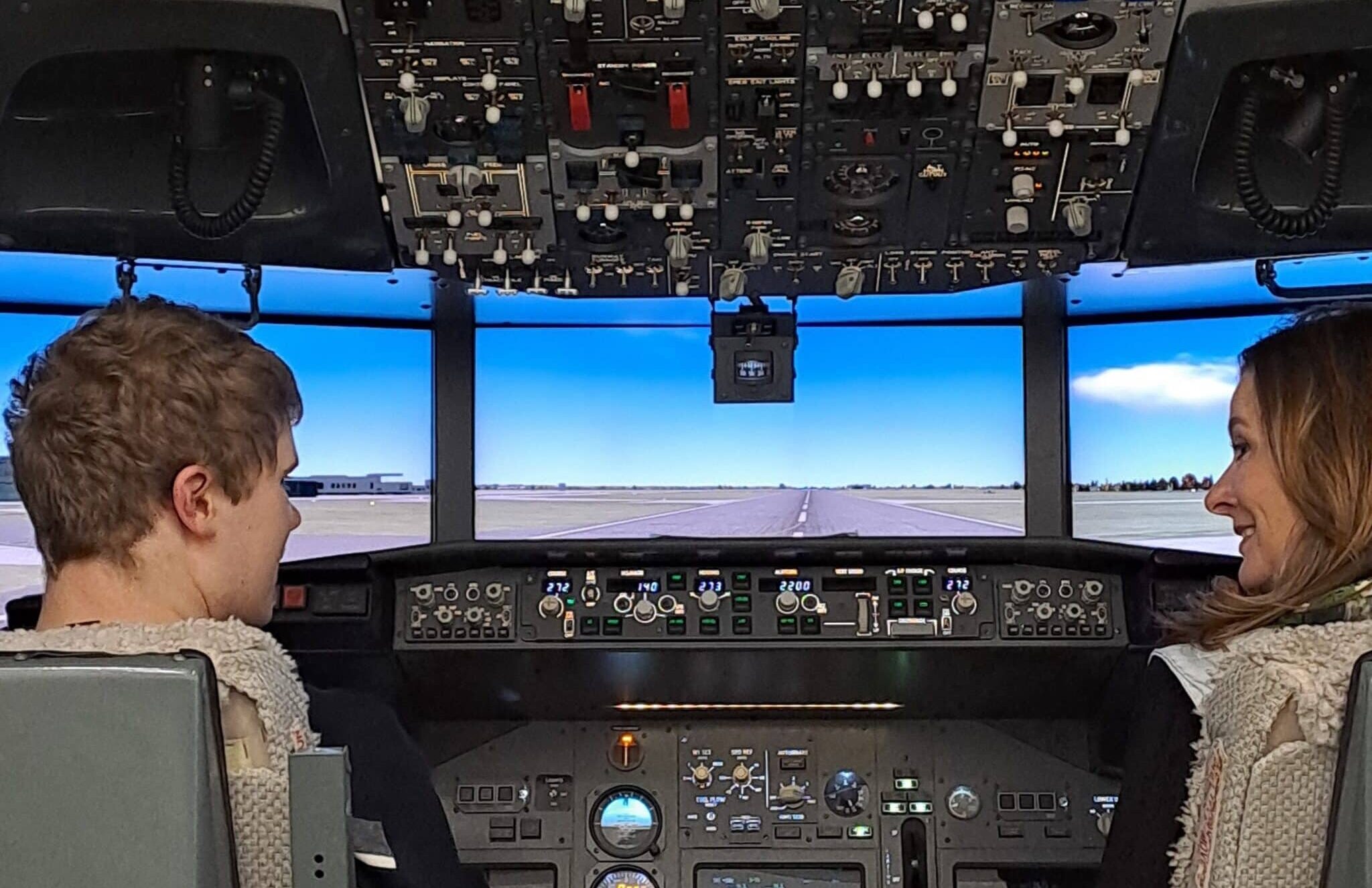 Gillian Keegan and student talking in flight simulator