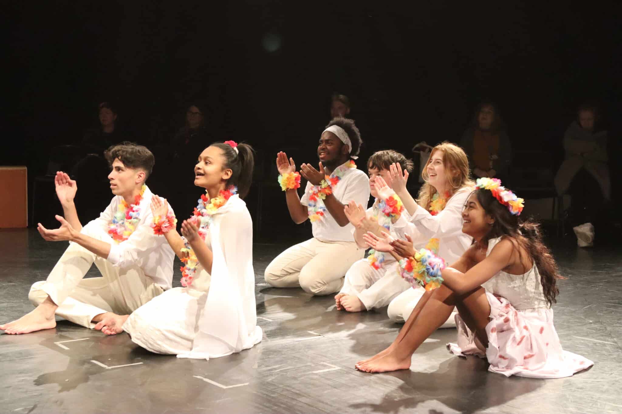 Performers sitting clapping
