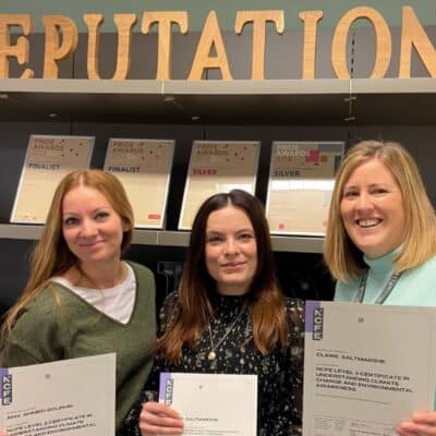 3 people standing holding certificate