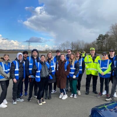 Policing students in blue high vis posing for group picture