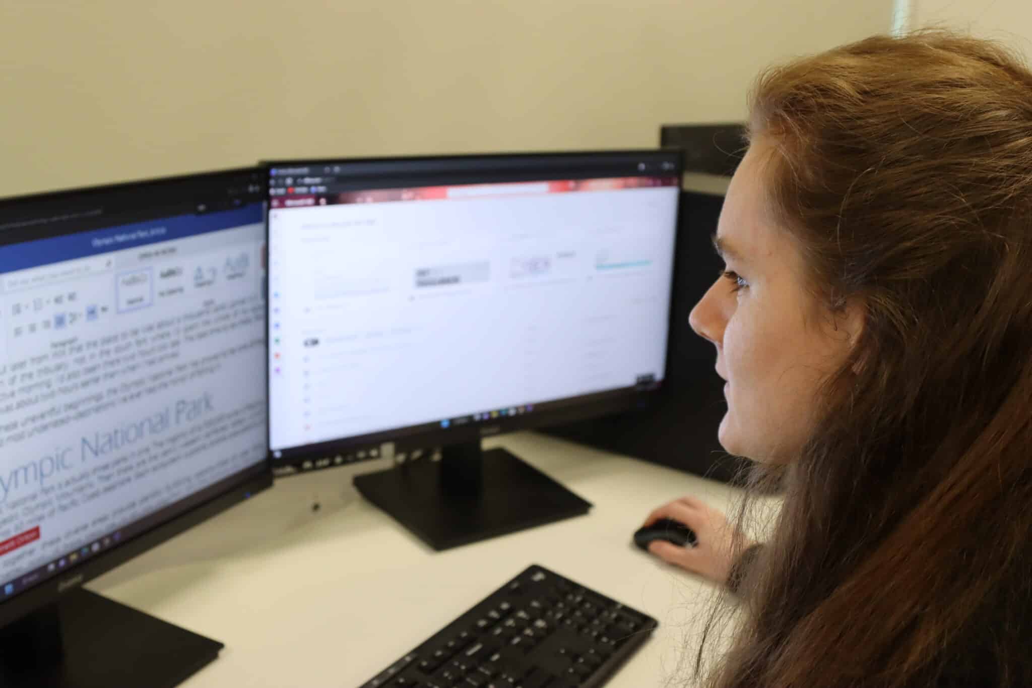 student sat in front of computer screens