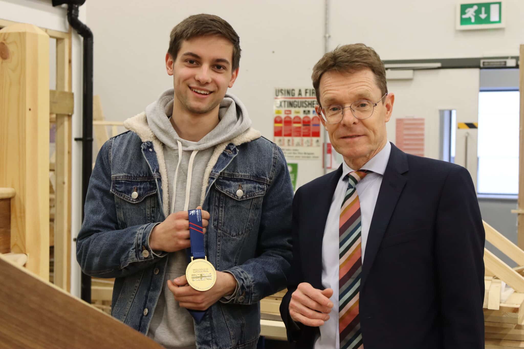 Harry standing next to Mayor Andy Street holding medal