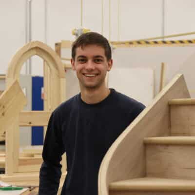 harry standing next to staircase he built