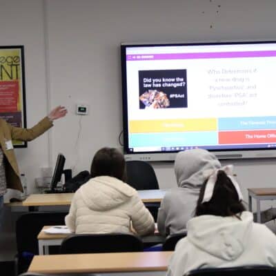 visitor pointing at screen as he delivers drug analysis session