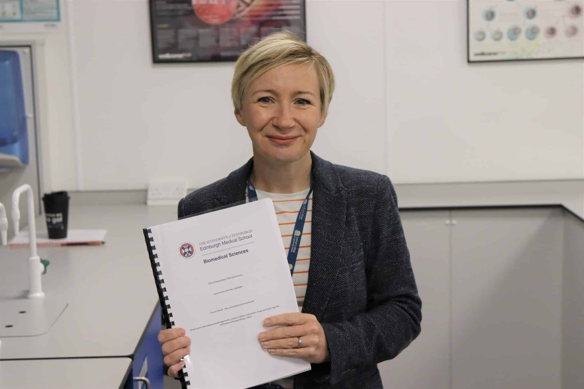 Claudine holding up degree certificate