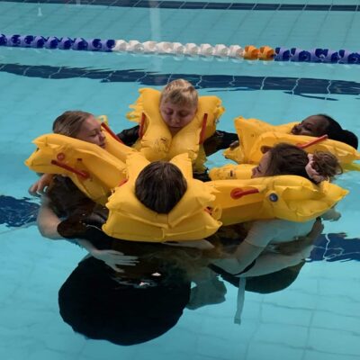 cabin crew students with life jackets in the pool at Tudor Grange