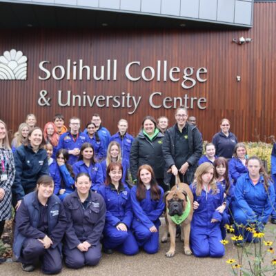 Students and staff with Cooper the dog outside the college