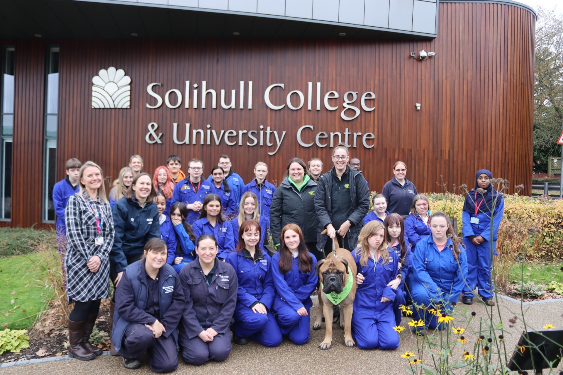 Students and staff with Cooper the dog outside the college