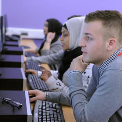 students sat in line looking at computer