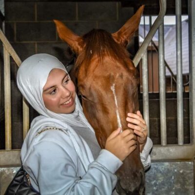 student stood next to horse