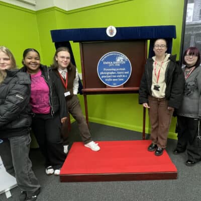 5 students stood next to blue plaque Emma Barton