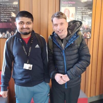 Two students looking at camera and smiling