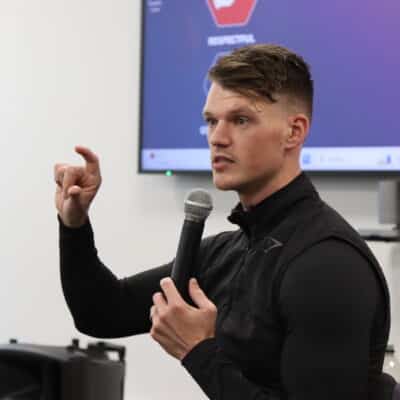 Ben Francis from Gymshark talking with a mic to students