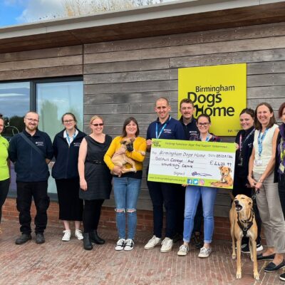 staff from solihull college & University centre handing over a large cheque to the staff at birmingham dogs home