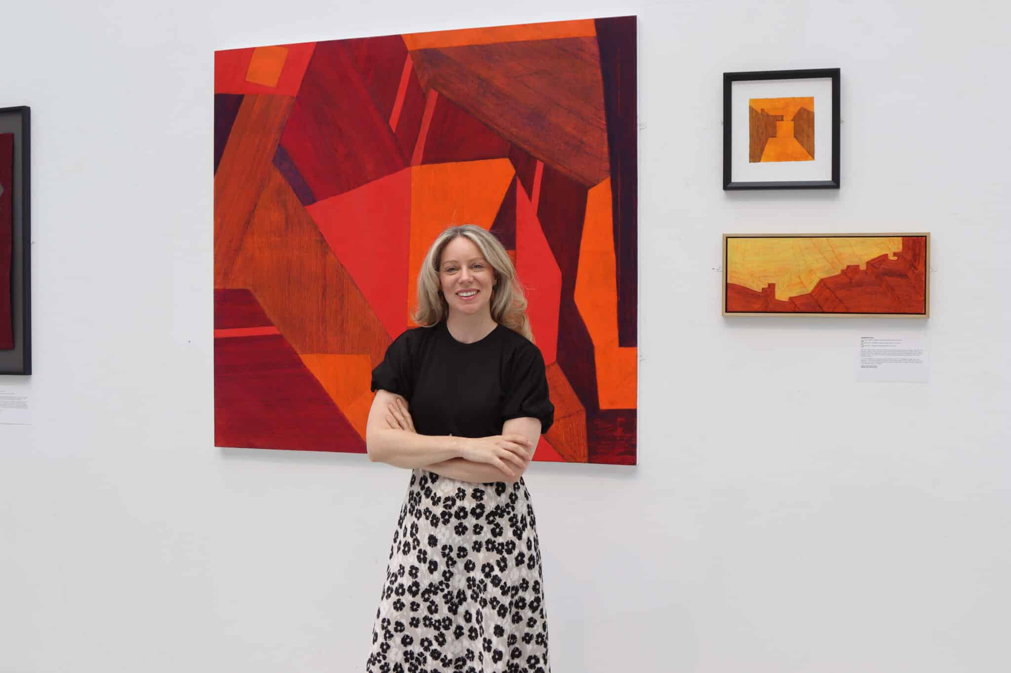 Ruth Millington standing in front of some of the featured artwork
