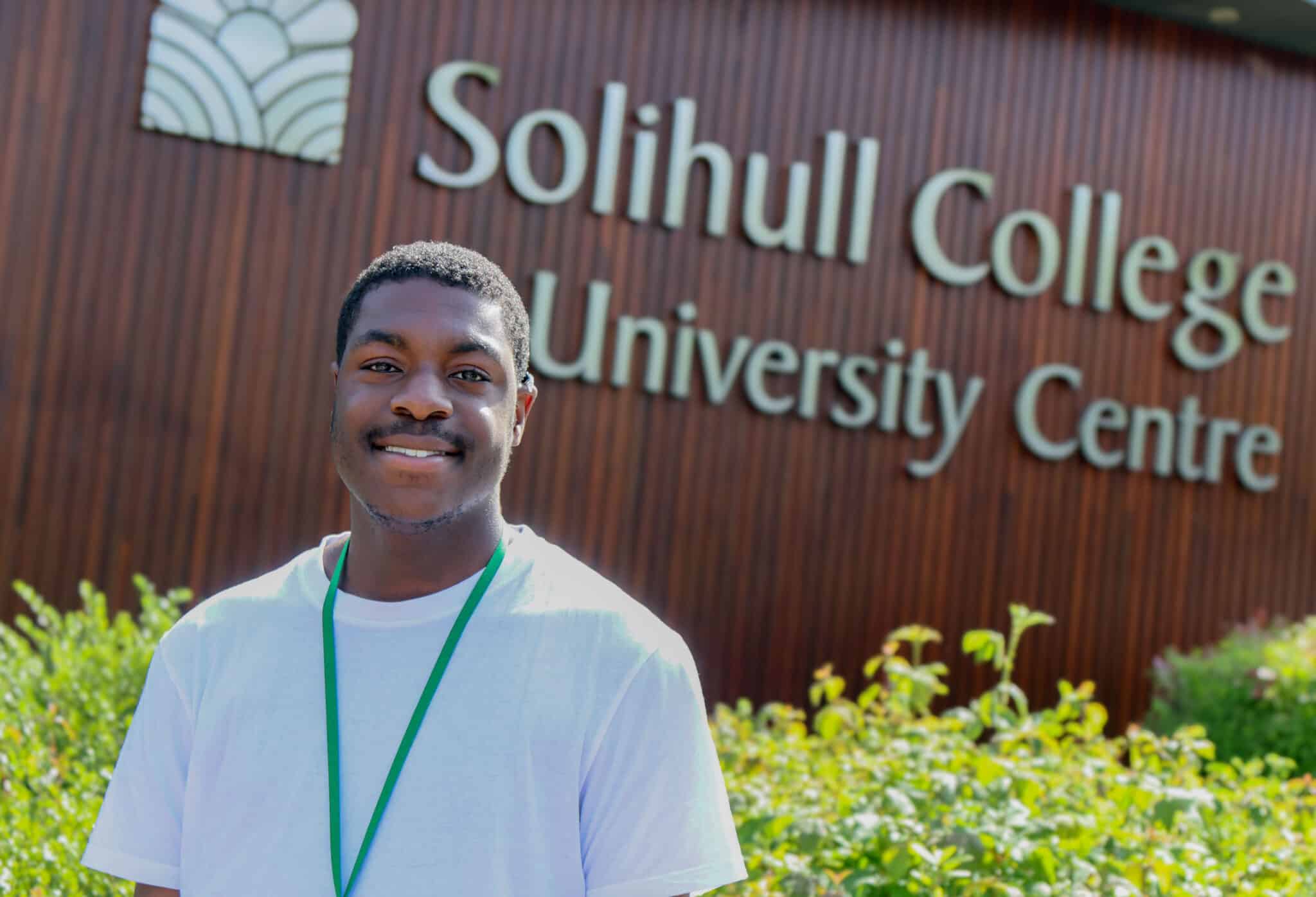 Tami standing in front of college logo