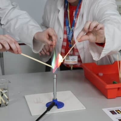2 students in a science lab playing with fire in a controlled experiment