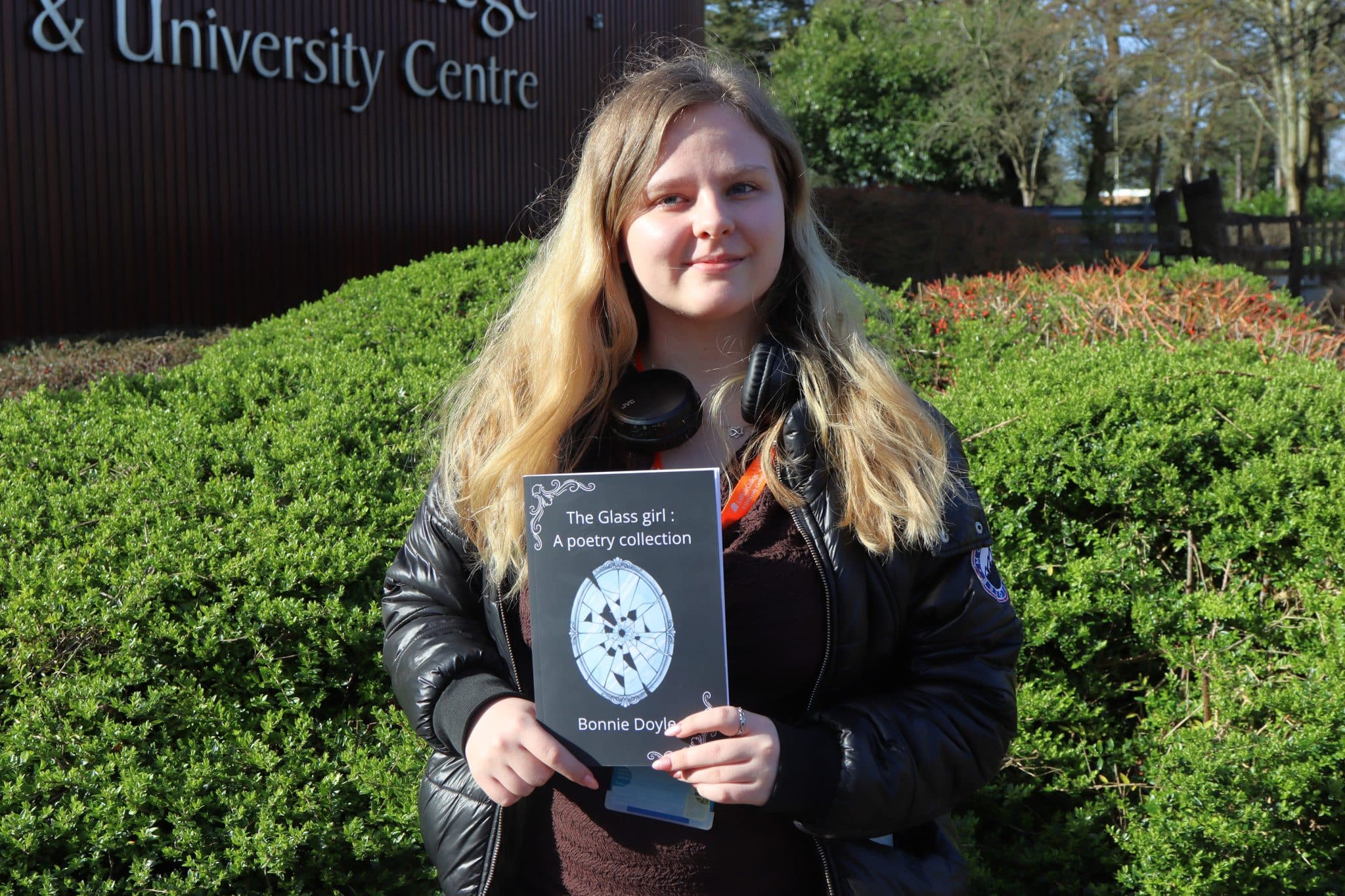 A student with blonde hair holding a poetry book