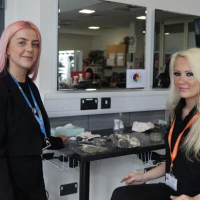 Student and teacher smiling at the sat at a make-up table