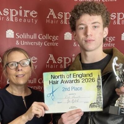 A student and a teacher holding a certificate.