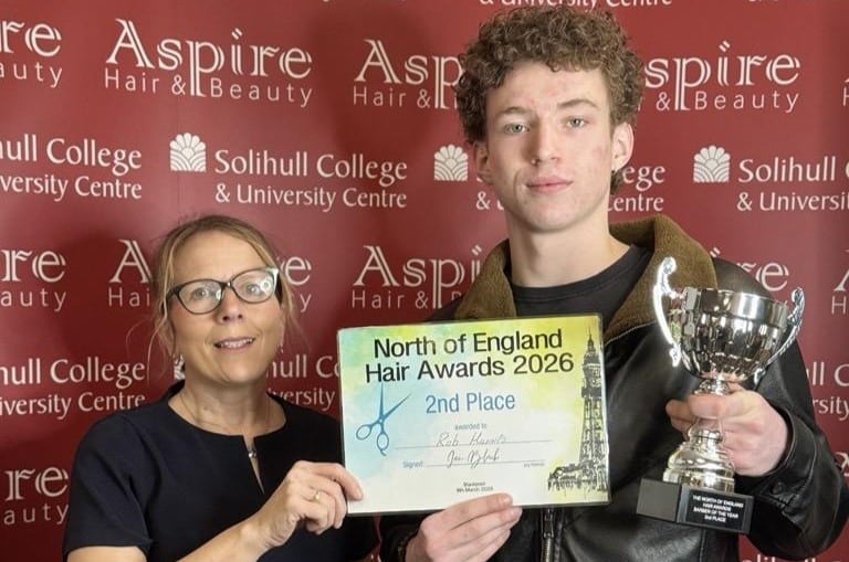 A student and a teacher holding a certificate.